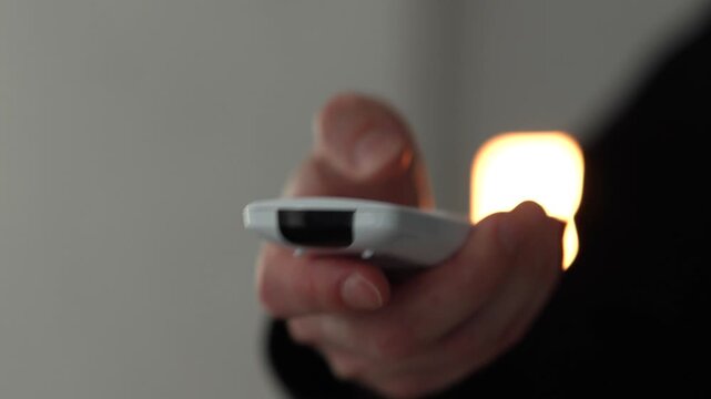 Ventilating a room with an air conditioner.
A man's hand presses a button to turn on the air conditioner.