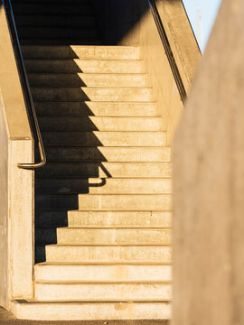 Concrete stairs with metal handrail in sunlight