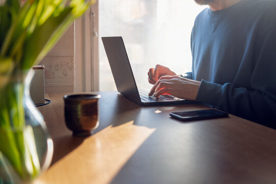 Midsection of male entrepreneur using laptop during work from home