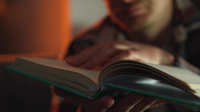 Reading a book in a cozy home atmosphere sitting on the sofa in the evening