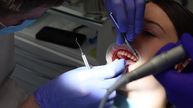Orthodontist applying dental braces to patient's teeth