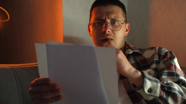 Preparing for entrance exams in the evening.
A guy focused on studying preparatory questions to successfully pass the college exam.