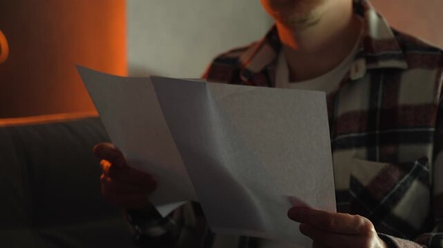 A man wearing glasses studies information before applying to college.
Important information on paper, reading the text, and analyzing it.