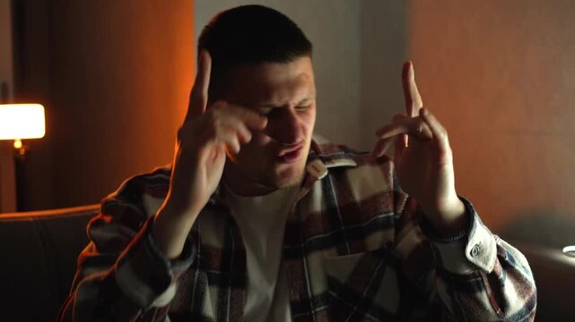 A guy dancing in a dark room, listening to loud music and dancing