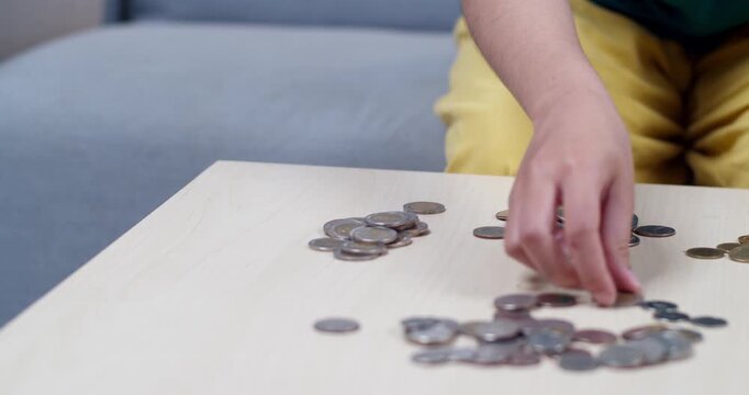 A person meticulously counts coins a table to manage personal finances effectively.