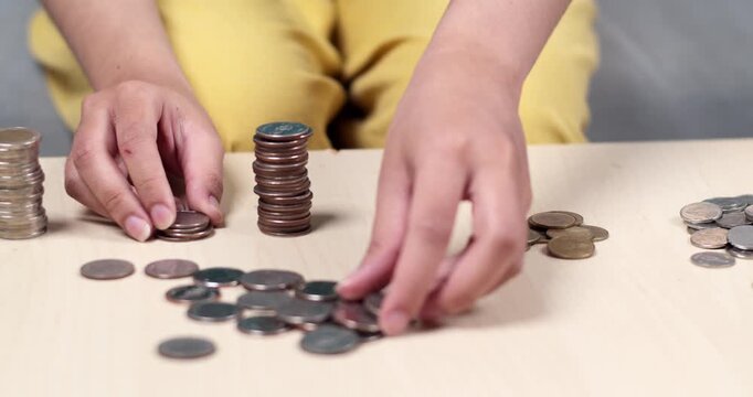 A child sorts and stacks coins learning to manage money through hands- play.