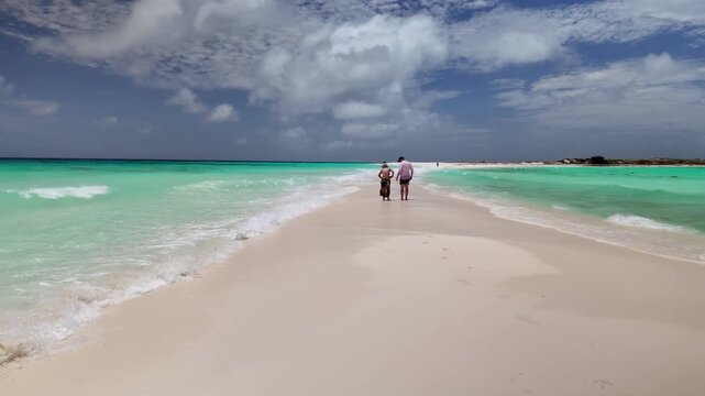 loving couple explores a secluded sandbank in crystalline Caribbean waters, capturing a serene moment of connection and blissful island escape in in Cayo de Agua Los Roques Venezuela