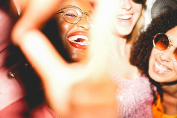 Crazy women friends having fun at night time listening music outdoor and taking photos together - Party, nightlife and people lifestyle concept - UGC flash content - Main focus on african girl face © DisobeyArt