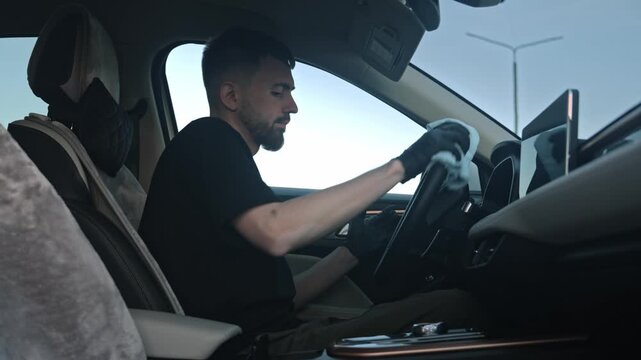White Man Valet Wiping Steering Wheel And Cabin Surfaces, Methodical Strokes With Microfiber, Black Gloves