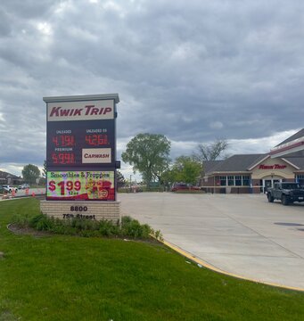 Pleasant Prairie, Wisconsin, USA - May 13, 2025: Kwik Trip gas station displaying gasoline prices above $4 per gallon beneath dark storm clouds in southeastern Wisconsin.