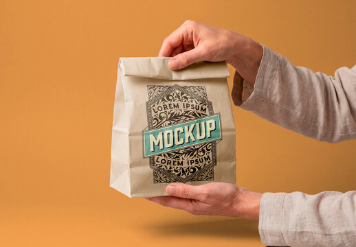 Paper lunch bag mockup in hands