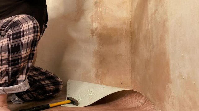 Person applying mold prevention spray on wall before primer application, home repair and renovation concept.