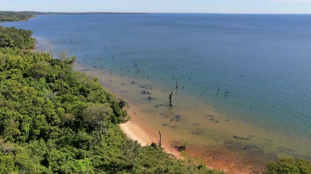 Lush green forest meets the sandy shore of Rio Paran&aacute; at Santa Tecla Beach, Corrientes. Ideal for travel content and nature documentaries.