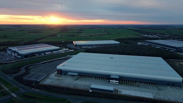Drone view of large scale warehouses and logistics hubs during golden hour.