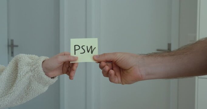 Close-up of a man symbolically handing a written password on paper to another person. Concept of weak security practices, data breach risk, information sharing, and cybersecurity awareness.