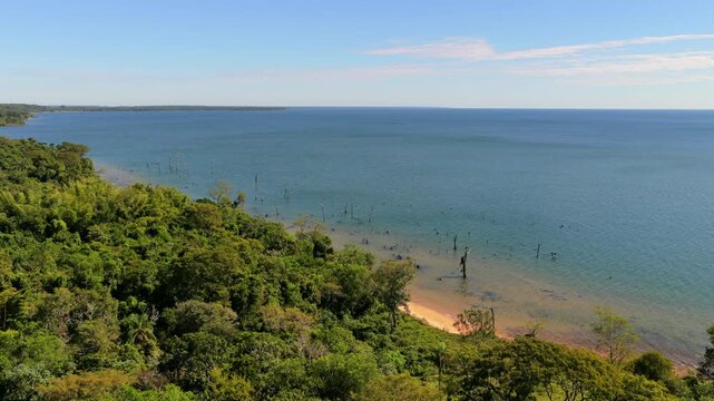 Aerial footage captures the expansive blue waters of the Rio Paran&aacute; alongside the lush green coastline of Corrientes, Argentina. Suitable for environmental documentaries or travel features.