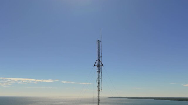 A tall communication tower stands prominently against a clear blue sky, with the Paran&aacute; River stretching out below. Ideal for telecommunications or infrastructure projects.