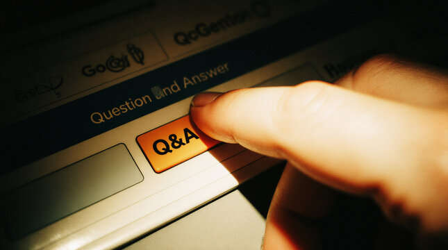 Close up of finger pressing Q and A button on digital interface representing online support, customer service, internet search and question answer concept.