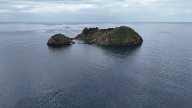 Cinematic aerial view of the Islet of Vila Franca do Campo (Ilh&eacute;u) in the Atlantic Ocean. Drone shot of the perfectly circular submerged volcanic crater near Sao Miguel Island, Azores