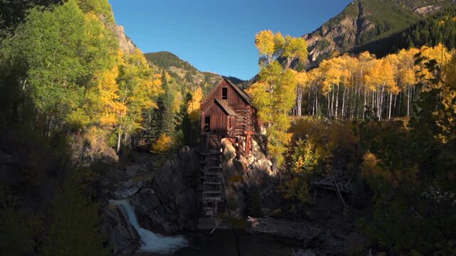 Crystal Mill Rocky Mountains Colorado famous iconic landmark fall Autumn old mining wood building waterfall lookout sunny blue sky late afternoon sunset Crystal River Canyon falls nature landscape pan