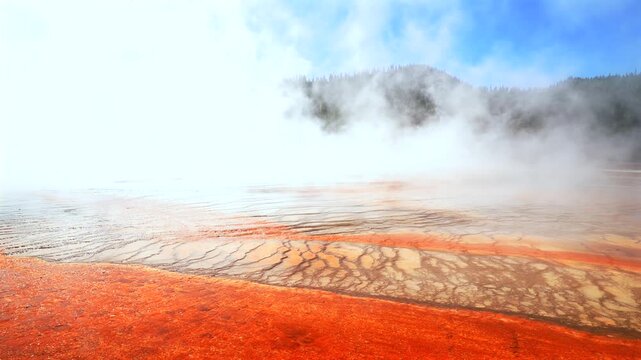 Grand Prismatic Spring dense steam Midway Boardwalk hiking trail Mid Geyser Basin Wyoming USA Yellowstone National Park nature landscape Opal Pool Morning Glory sunny morning blue sky pan left motion