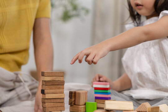 Happy children play and learn, education, homeschool little girl create wooden toy block build the house, improving intelligence and knowledge with mother, supporting emotional quotient creativity