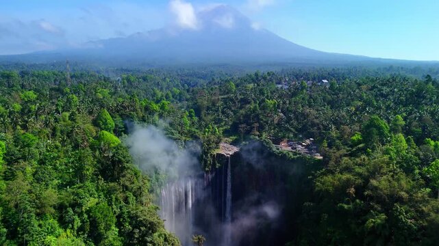 Aerial view of Tumpak Sewu Waterfall with Mount Semeru in the background, Kecamatan Pronojiwo, Jawa Timur, Indonesia.