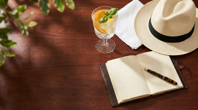 Luxury summer maritime flatlay with Panama hat, open journal and iced water