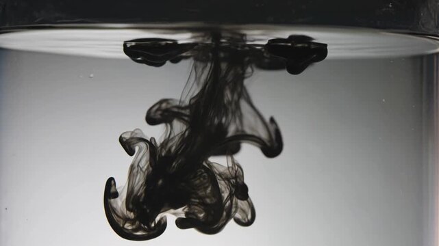 Black Ink Swirling and Dissolving in Clear Water, Abstract Macro Slow Motion Dark Background