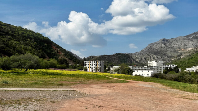 Canj coastline with grassy foreground and low coastal hotels under scattered clouds