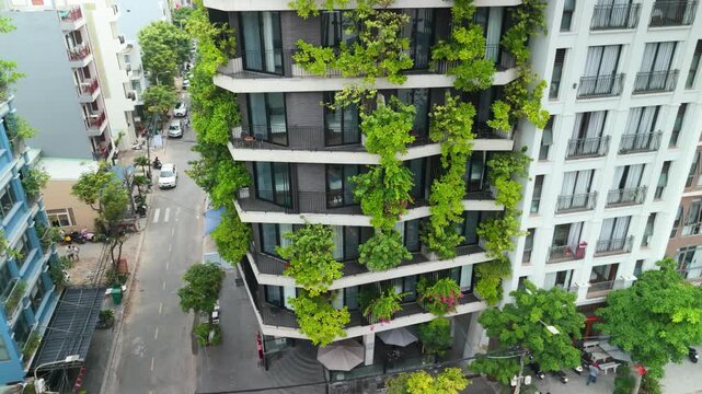 Contemporary urban building facade incorporating lush green vertical gardens and balconies, highlighting sustainable living, eco friendly architecture, and biophilic design in a city environment