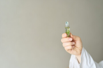 Hand Holding Cosmetic Serum Bottle On Neutral Background, Skincare Treatment, Beauty Wellness, Minimal Product Presentation And Selfcare Routine Concept. © elenavolf