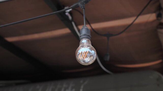 Warm yellow festival light bulbs hanging on string at night outdoor event
