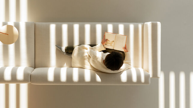 ソファで本を読む人の俯瞰とやわらかい光