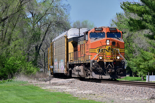 A single locomotive leads a Burlington Northern Santa Fe auto rack train eastbound through a curve while passing along a rural stretch of right-of-way in north central Illinois. 