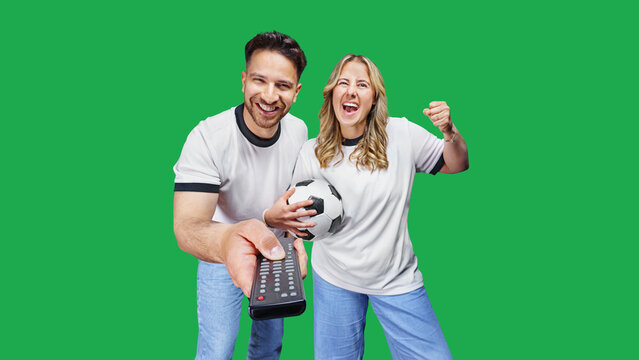 A man and a woman are switching on a soccer game using the remote control on the TV. Watch live stream soccer and sports at home.