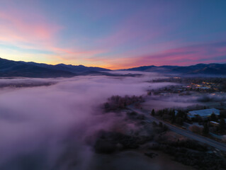 Fototapeta premium Aerial view valley fog covering a beautiful landscape during dawn