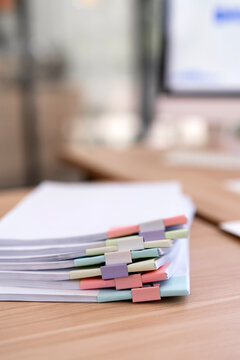 Stack of Documents with Colorful Paper Clips on Office Desk