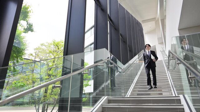 [スローモーション]オフィスビルで若手新卒営業社員が目標と未来へ向かう歩く姿の成長と挑戦のキャリアビジネスイメージ全身の広角動画