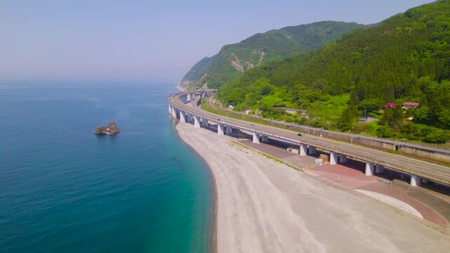 親不知海岸の絶景と北陸自動車道 海岸線に沿って前進するハイアングル空撮