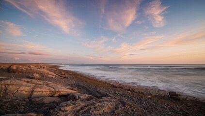 Obraz premium Breathtaking early morning sky over a textured shoreline with waves