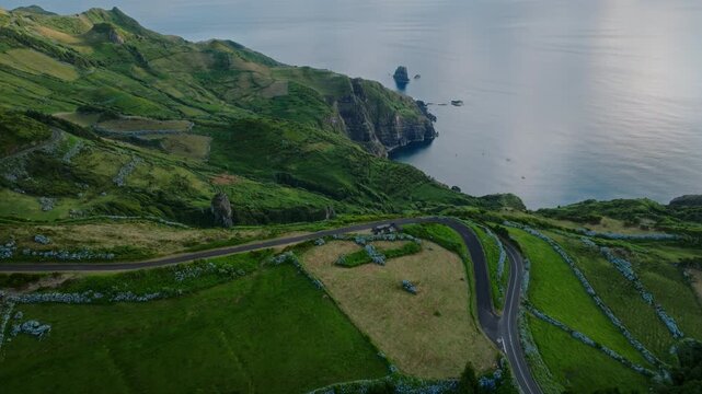 Cinematic Aerial Drone View of a Winding Mountain Road Overlooking Dramatic Coastal Cliffs and the Atlantic Ocean, Flores Island