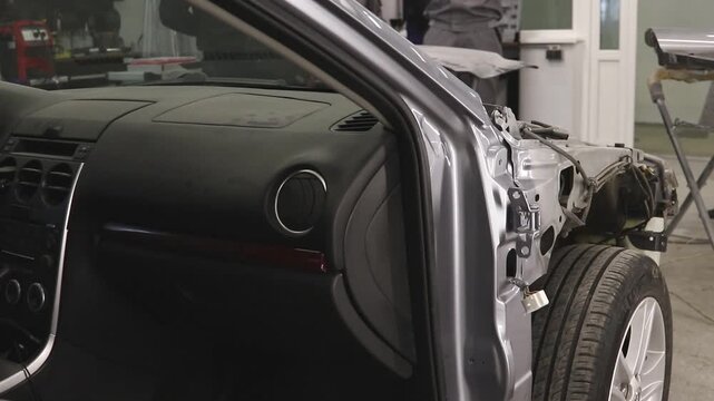 Car undergoing body repair in a modern auto repair shop during restoration after damage.