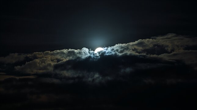 Dramatic moonlight breaking through dark storm clouds at midnight sky