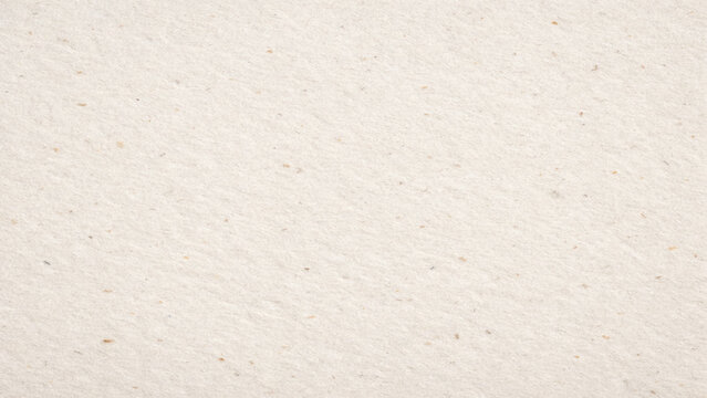 Textured paper background, close-up of beige speckled paper