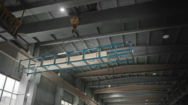 Overhead Crane Transports Materials Smoothly. Inspectors Examine Rigging During Steady Movement