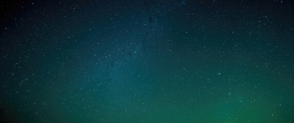 Fototapeta premium bright green and blue celestial sky filled with sparkling stars