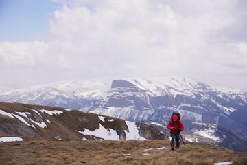Fototapeta premium A traveler in the mountains uses a navigator. A man in the mountains looks at his phone and determines his location