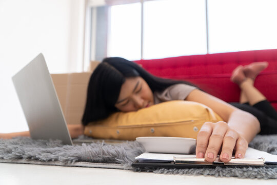 Tired and Overwhelmed: a woman rests amidst work, her face nestled against a pillow, a laptop nearby, illustrating the weight of modern-day pressure.