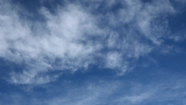 White and gray clouds move in two directions in this timelapse filling the bluse sky. The sky fills the frame.
